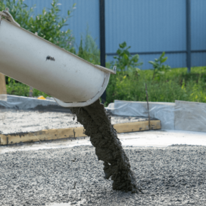 Image of a concrete pump pouring concrete onto a foundation during a product presentation.